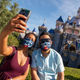Guests take a selfie in front of Sleeping Beauty's castle at Disneyland on its reopening day, April 30.